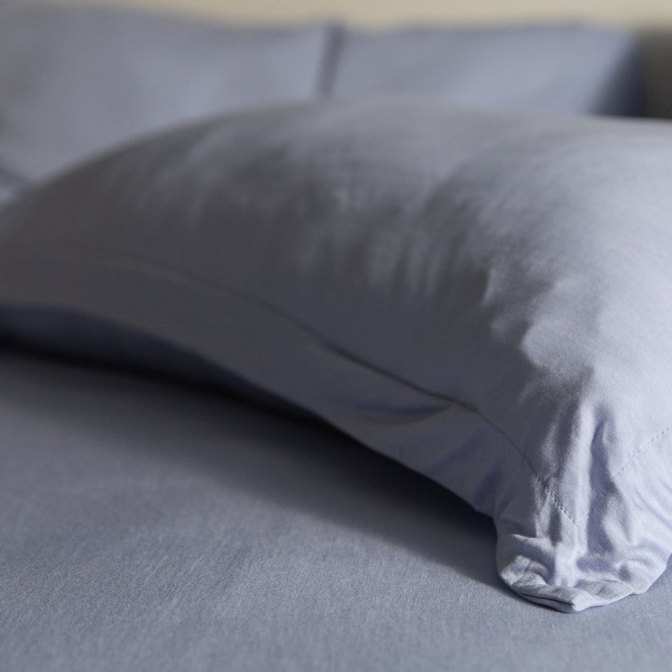 Gray pillow on a bed with a blurred background
