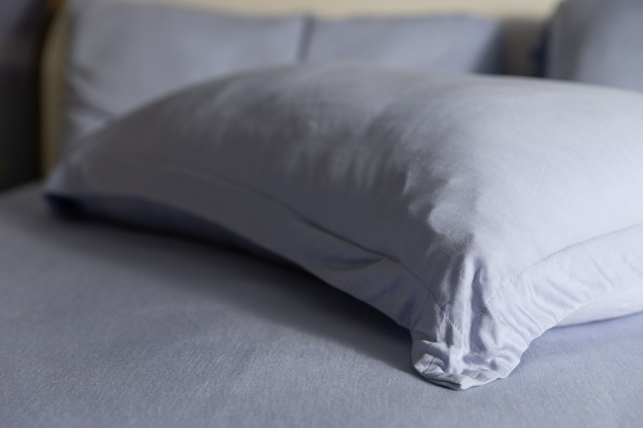 Gray pillow on a bed with a blurred background