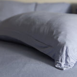 Gray pillow on a bed with a blurred background