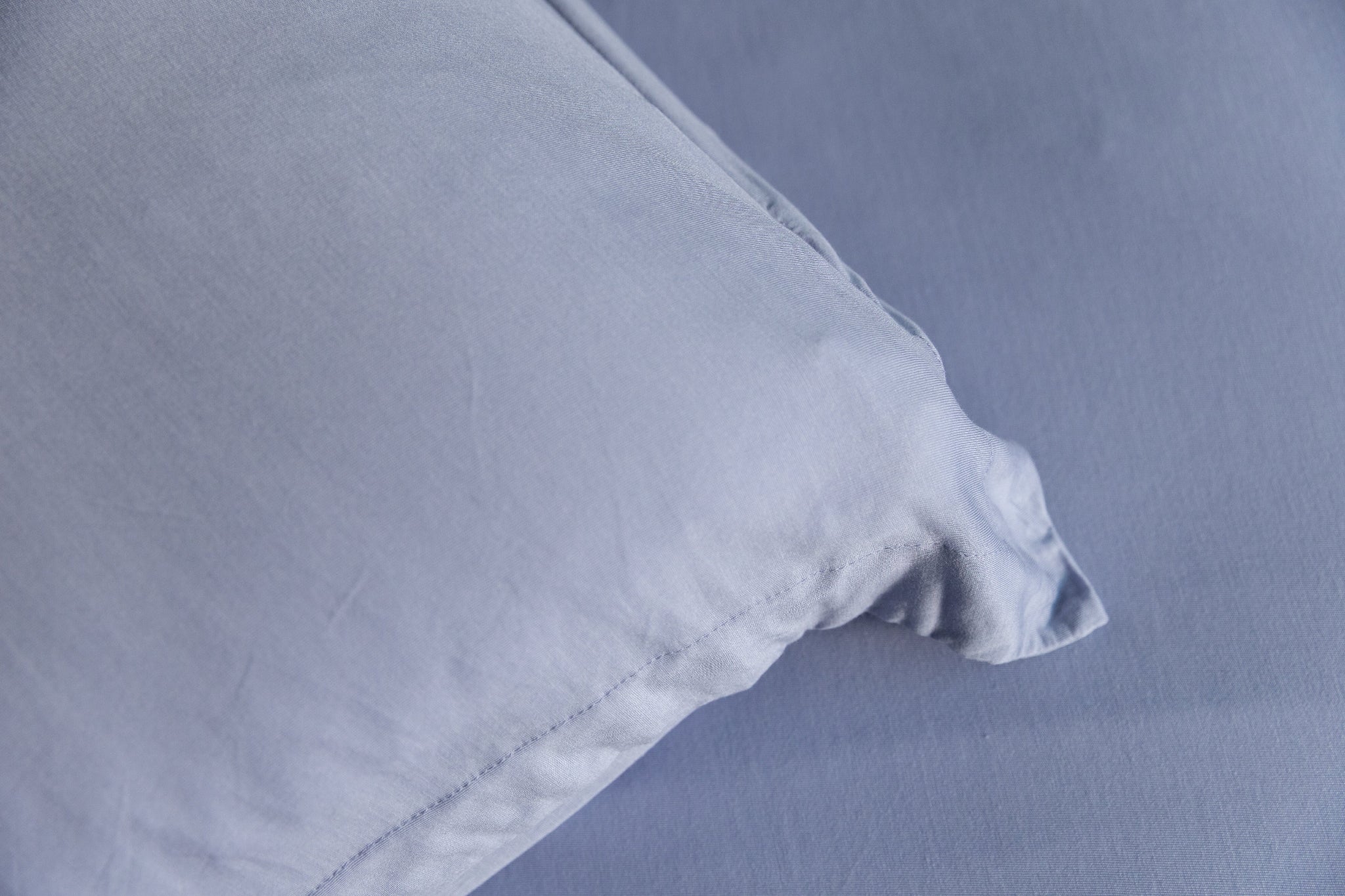 Close-up of a light blue pillow on a matching fabric background