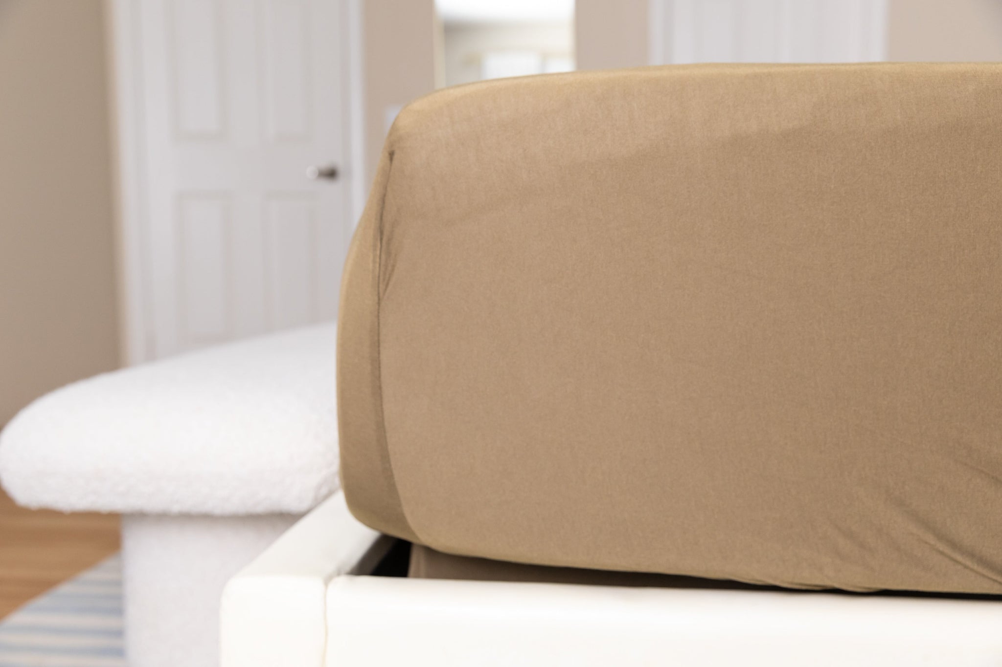 Brown fitted sheet on a white bed in a bedroom setting