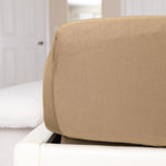 Brown fitted sheet on a white bed in a bedroom setting