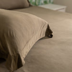 green pillow sham on a bed with a blurred background