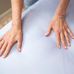 Close-up of a person's hands on a light blue fabric