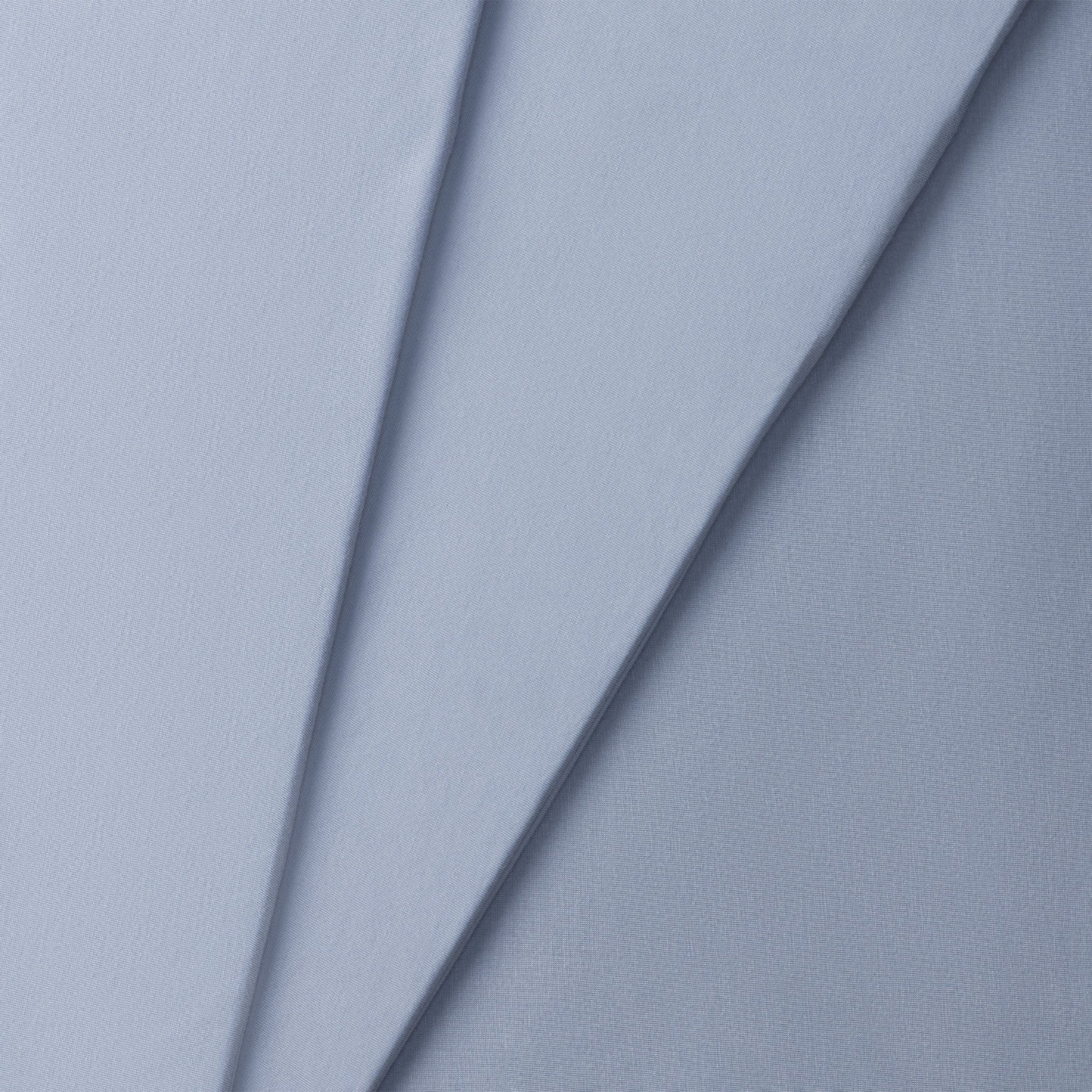 Close-up of a jersey knit textured blue fabric with a subtle pattern