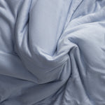 Close-up of jersey knit light blue fabric with folds