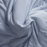 Close-up of jersey knit light blue fabric with folds