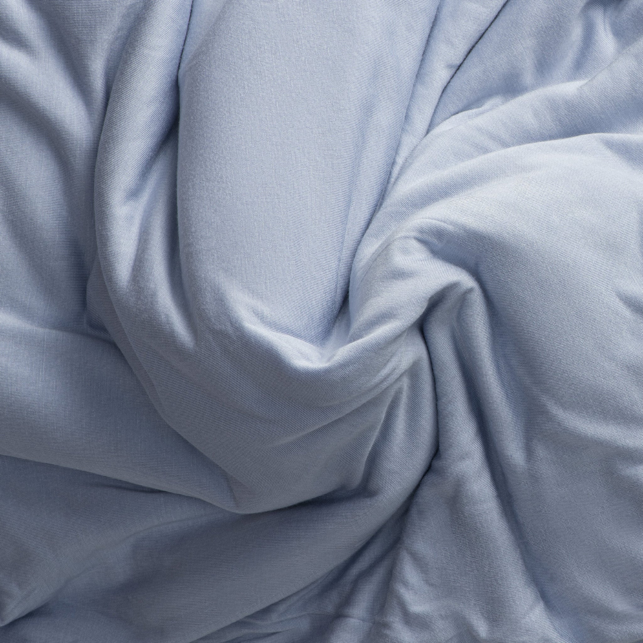 Close-up of jersey knit light blue fabric with folds