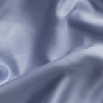 Close-up of sateen blue fabric with folds and shadows