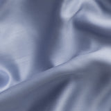 Close-up of sateen blue fabric with folds and shadows