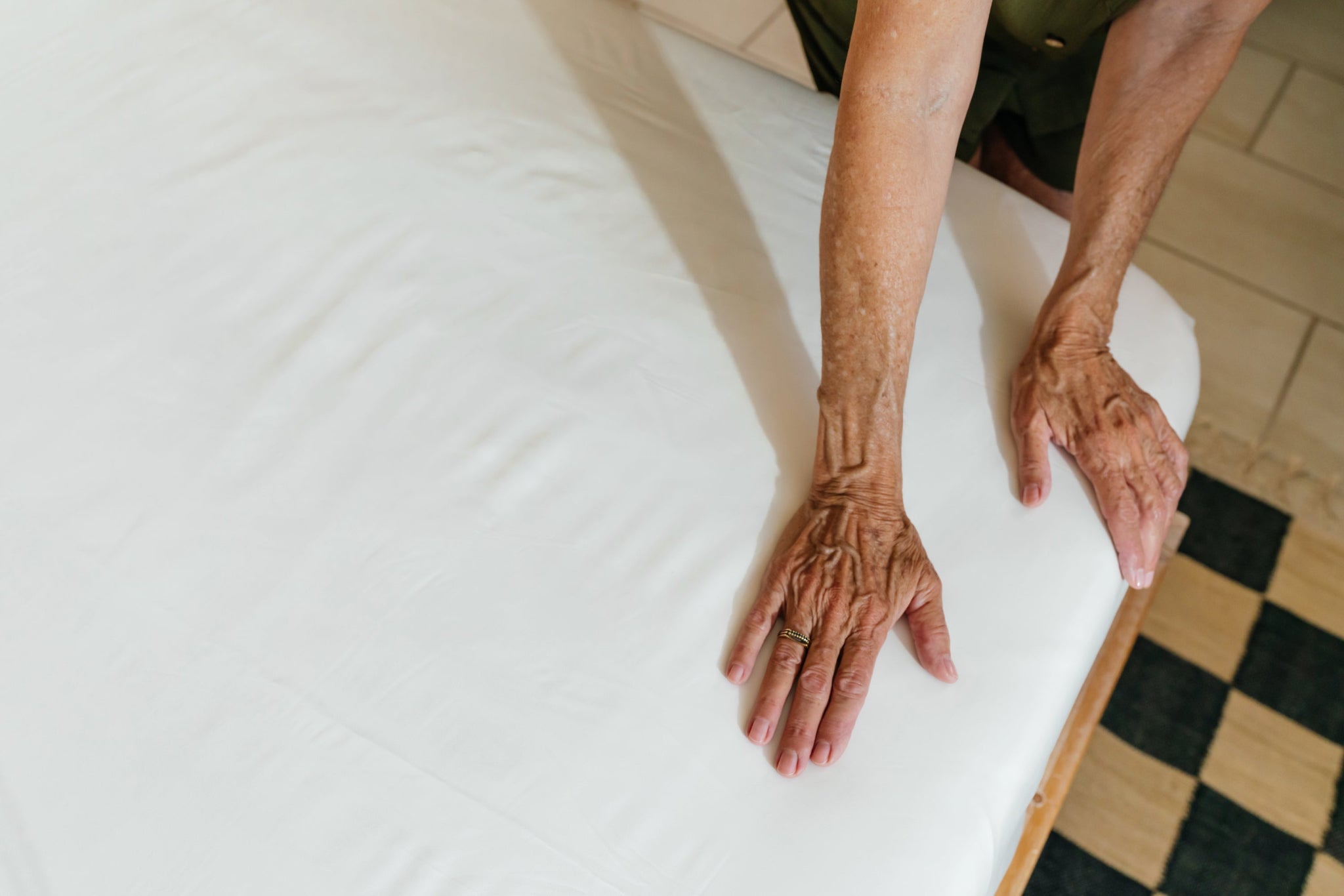 old woman hands on sateen fabric